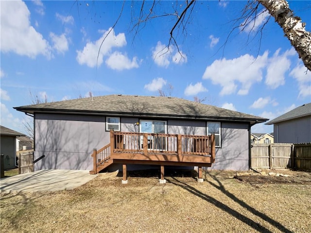 rear view of house featuring a wooden deck and a patio area