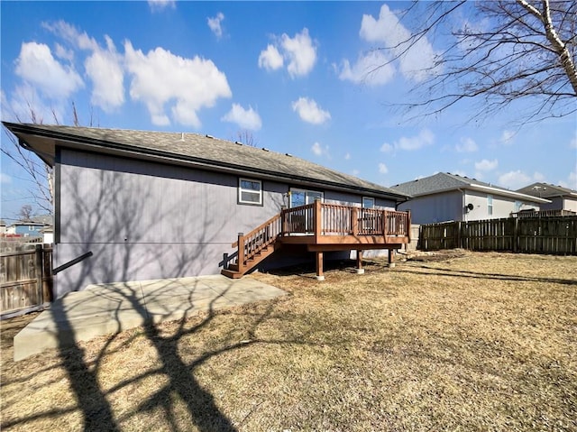 rear view of house featuring a yard and a deck