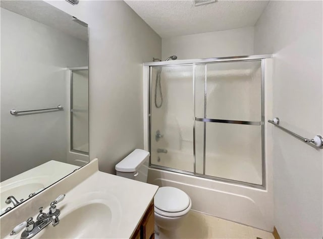 full bathroom featuring enclosed tub / shower combo, vanity, toilet, and a textured ceiling