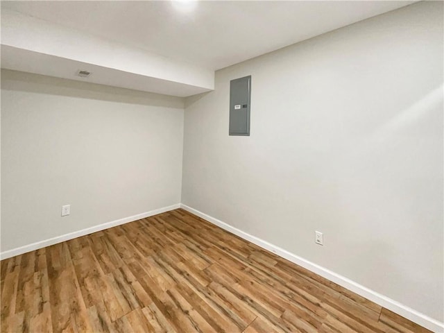 basement featuring hardwood / wood-style flooring and electric panel