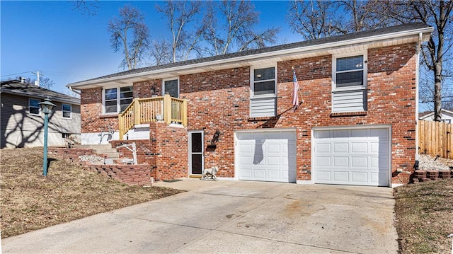 view of front of property featuring a garage, fence, concrete driveway, and brick siding