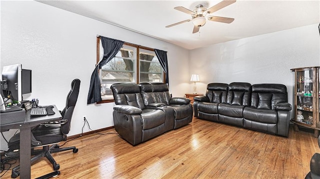 living room with wood-type flooring, ceiling fan, and baseboards