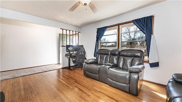 living room with ceiling fan, baseboards, and hardwood / wood-style flooring