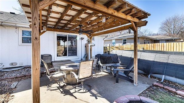 view of patio / terrace with a fenced backyard, a fire pit, a ceiling fan, and outdoor dining space