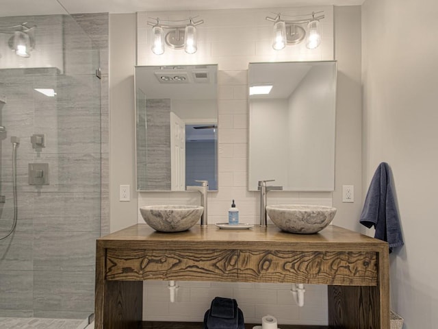 bathroom featuring tiled shower and vanity