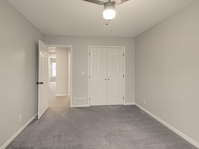 unfurnished bedroom featuring baseboards, visible vents, a ceiling fan, carpet floors, and a closet