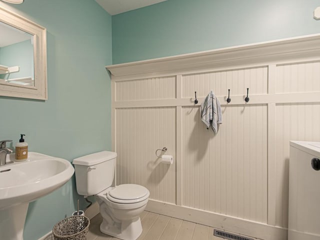 bathroom featuring toilet, a sink, and wood finished floors