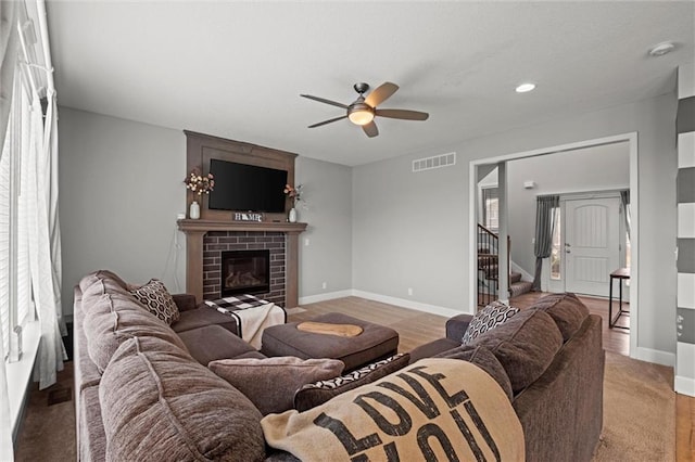 living room with a fireplace and ceiling fan