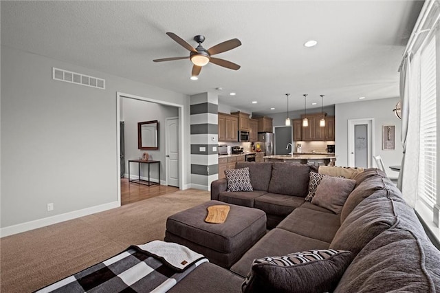 carpeted living room featuring ceiling fan