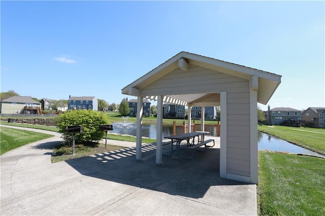 view of property's community with a yard, a water view, and a gazebo