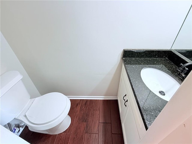 bathroom with hardwood / wood-style floors, toilet, and vanity