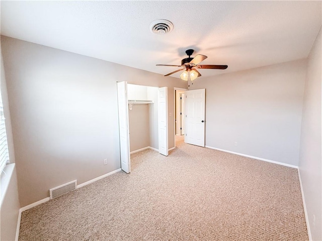 unfurnished bedroom with light carpet, a closet, and ceiling fan