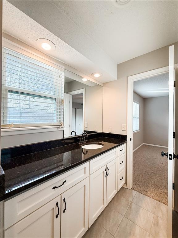 bathroom featuring a textured ceiling, tile patterned flooring, and vanity