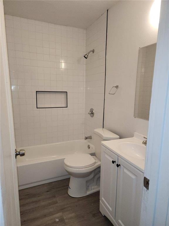 full bathroom featuring vanity, hardwood / wood-style flooring, toilet, and tiled shower / bath