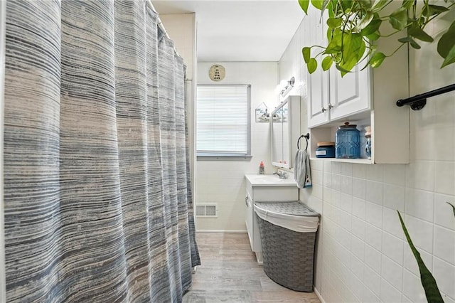 746 Salem Rd, Excelsior Springs, MO 64024 - bathroom featuring tile walls, wood finished floors, vanity, and a shower with curtain