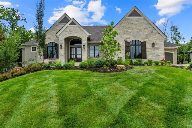 24982 W 106th Ct, Olathe, KS 66061 - french country inspired facade with stone siding, a front lawn, a garage, and french doors