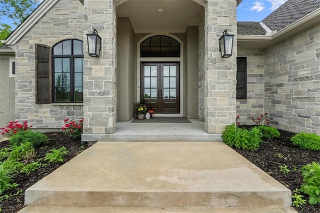 24982 W 106th Ct, Olathe, KS 66061 - doorway to property featuring french doors, stone siding, and a shingled roof