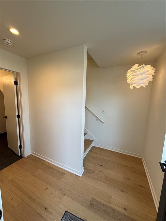 interior space featuring recessed lighting, baseboards, wood finished floors, and stairs