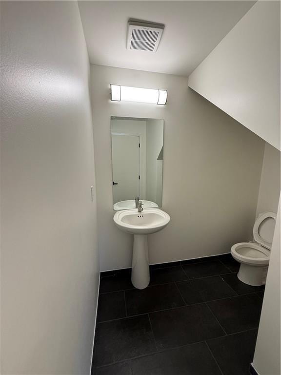 bathroom featuring tile patterned flooring, visible vents, and toilet