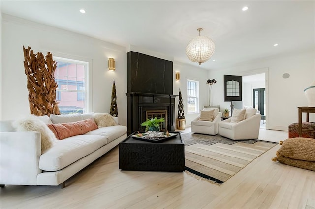 living room with recessed lighting, a large fireplace, and light wood-style floors