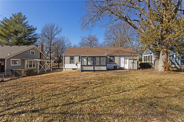 rear view of house with a storage shed and a yard