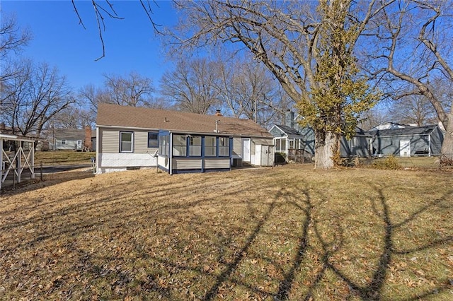 back of house featuring a sunroom and a yard