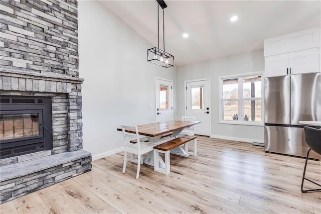 dining space featuring light hardwood / wood-style flooring and high vaulted ceiling