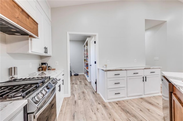 kitchen featuring light hardwood / wood-style floors, custom range hood, light stone countertops, gas stove, and white cabinets