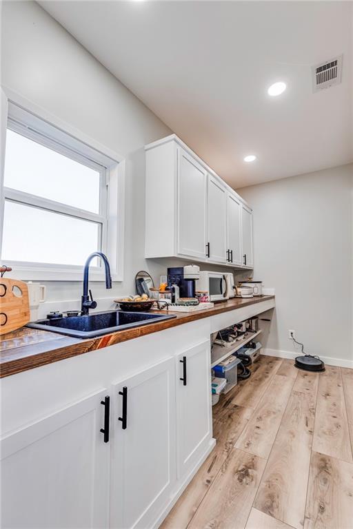 laundry area with sink and light hardwood / wood-style flooring