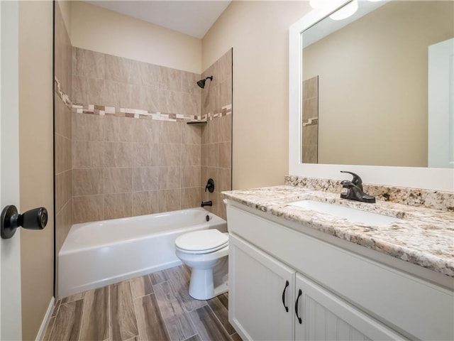 full bathroom with tiled shower / bath, wood-type flooring, toilet, and vanity