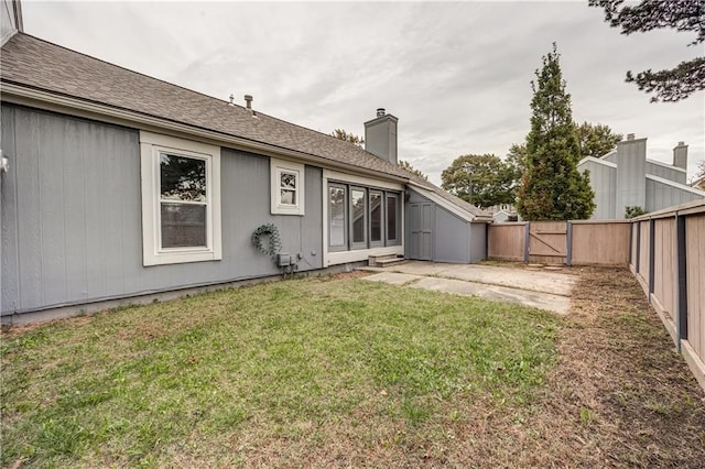 rear view of property featuring a yard and a patio area