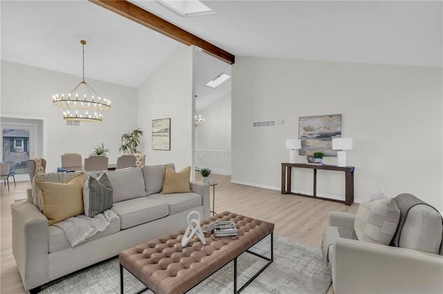 living room with an inviting chandelier, a skylight, high vaulted ceiling, light hardwood / wood-style floors, and beamed ceiling