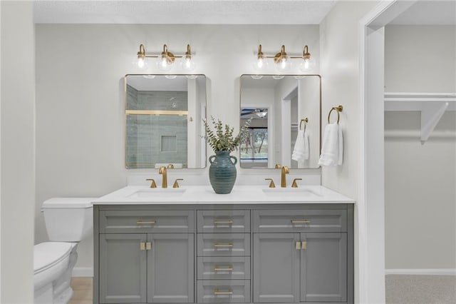 bathroom featuring vanity, toilet, a shower with shower door, and a textured ceiling