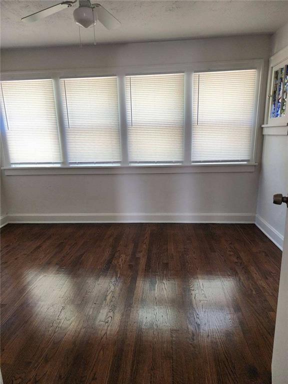 empty room featuring ceiling fan and dark hardwood / wood-style floors