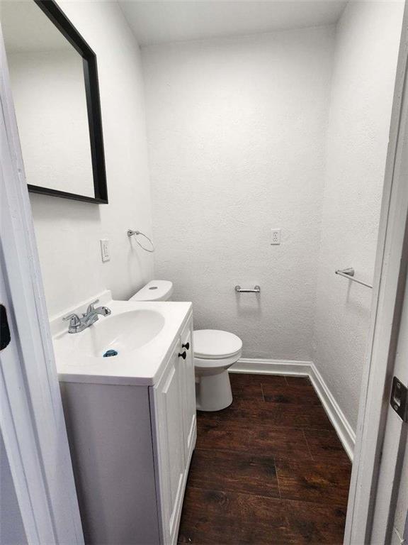 bathroom featuring vanity, hardwood / wood-style floors, and toilet