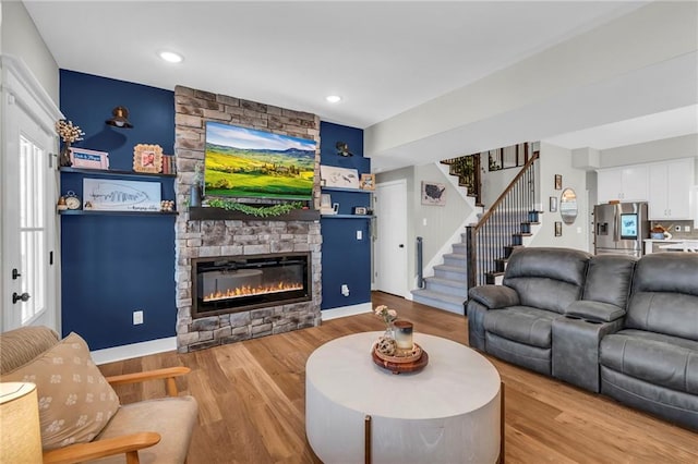 living room with stairs, a fireplace, wood finished floors, and recessed lighting