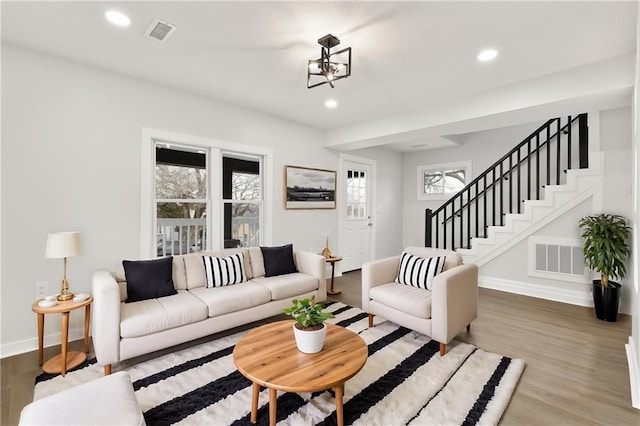 living room with stairway, visible vents, wood finished floors, and recessed lighting