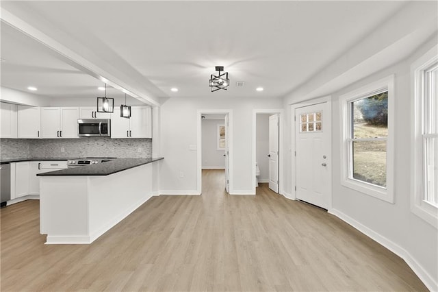 kitchen with dark countertops, white cabinetry, tasteful backsplash, and appliances with stainless steel finishes