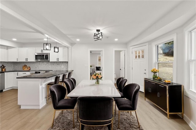 dining area featuring light wood finished floors and recessed lighting