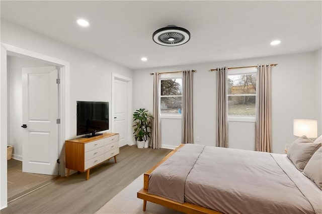 bedroom with baseboards, recessed lighting, and light wood-style floors