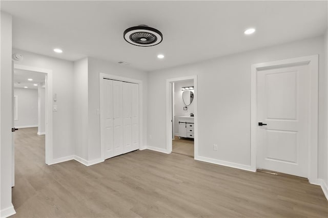 unfurnished bedroom with baseboards, connected bathroom, light wood-style flooring, and recessed lighting