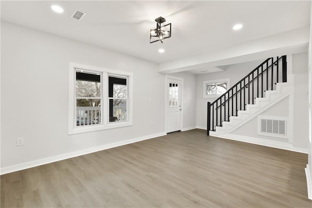 foyer featuring stairway, wood finished floors, visible vents, and baseboards