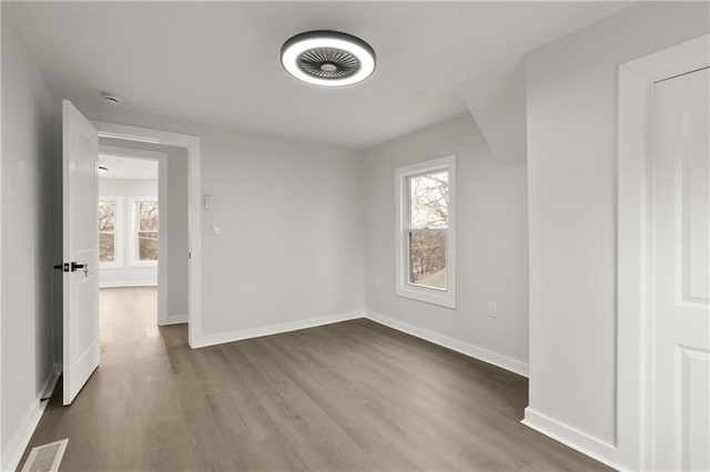 unfurnished bedroom featuring baseboards, visible vents, and wood finished floors