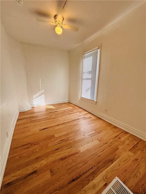 empty room with ceiling fan and light hardwood / wood-style floors