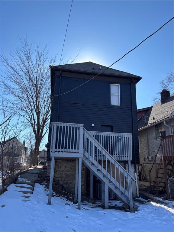 snow covered house with a wooden deck