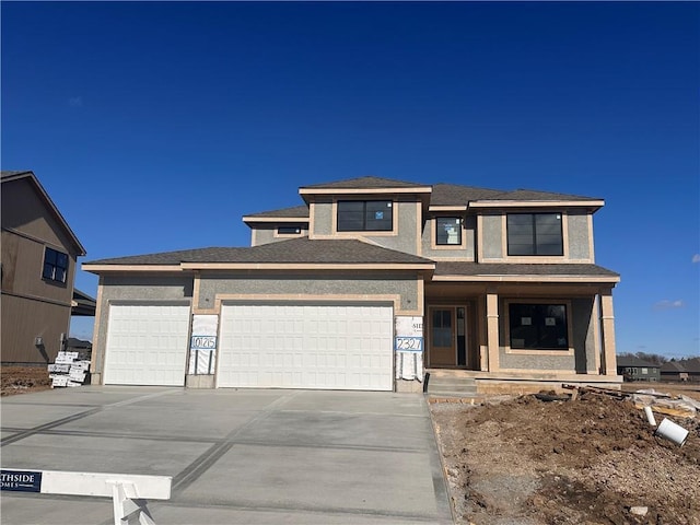 view of front of property with an attached garage, concrete driveway, and stucco siding