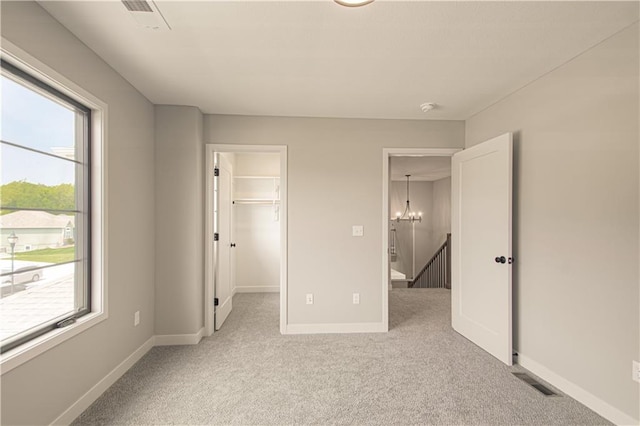2327 Fishing Ln, Kearney, MO 64060 - unfurnished bedroom featuring light carpet, multiple windows, and a chandelier