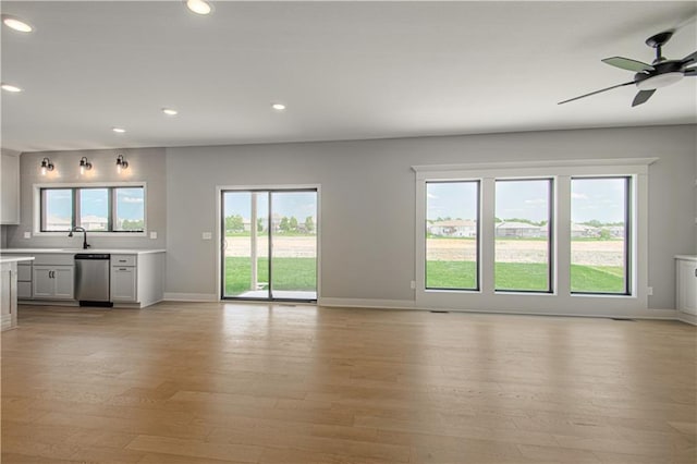 2327 Fishing Ln, Kearney, MO 64060 - unfurnished living room with baseboards, light wood-style flooring, recessed lighting, a ceiling fan, and a sink