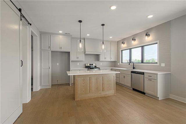 2327 Fishing Ln, Kearney, MO 64060 - kitchen featuring stainless steel appliances, light countertops, tasteful backsplash, light wood-style flooring, and a kitchen island