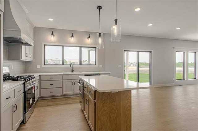2327 Fishing Ln, Kearney, MO 64060 - kitchen featuring gas range, premium range hood, light wood-style flooring, a sink, and backsplash